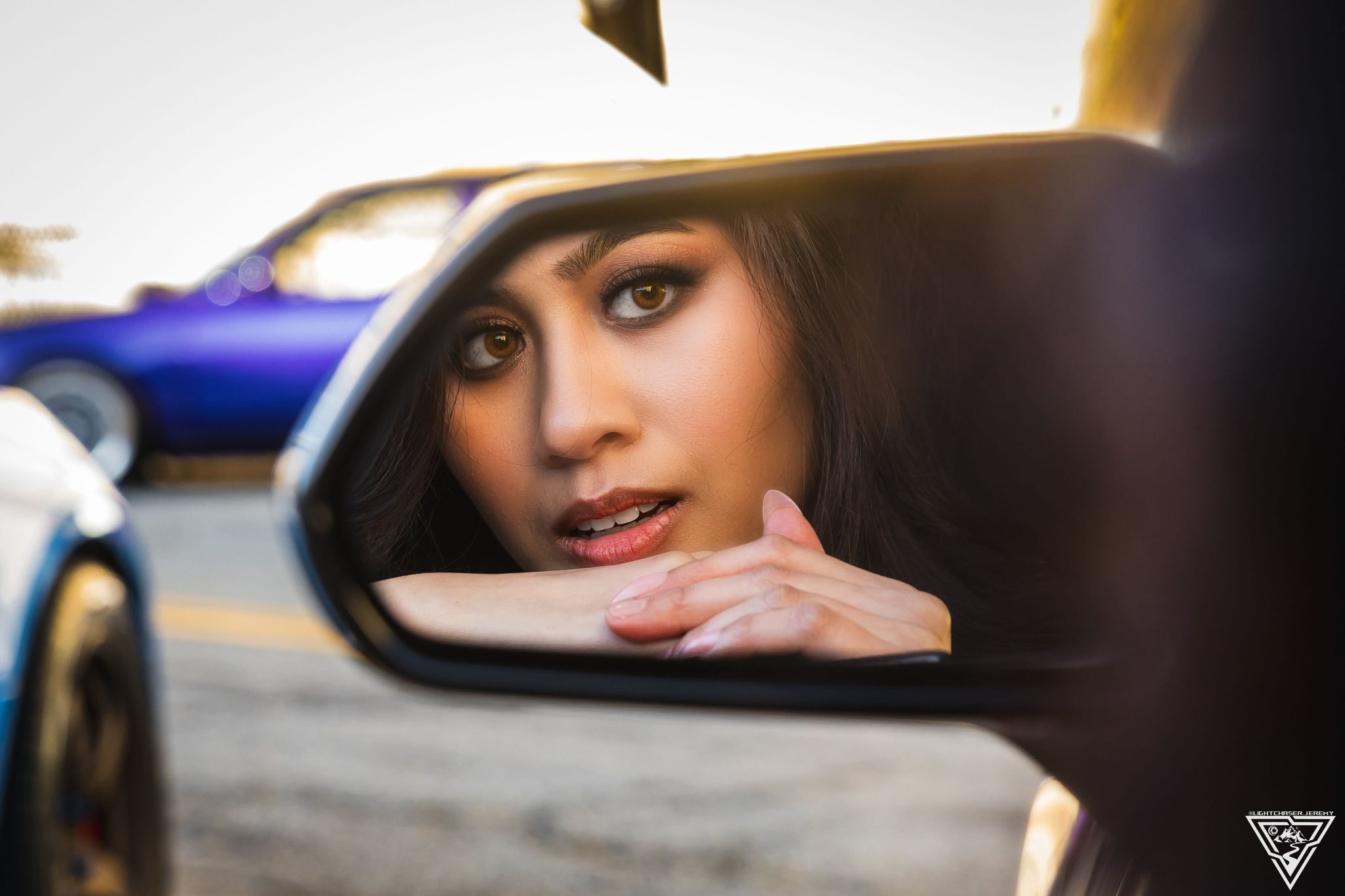 Joan Cruz reflected in a car side mirror