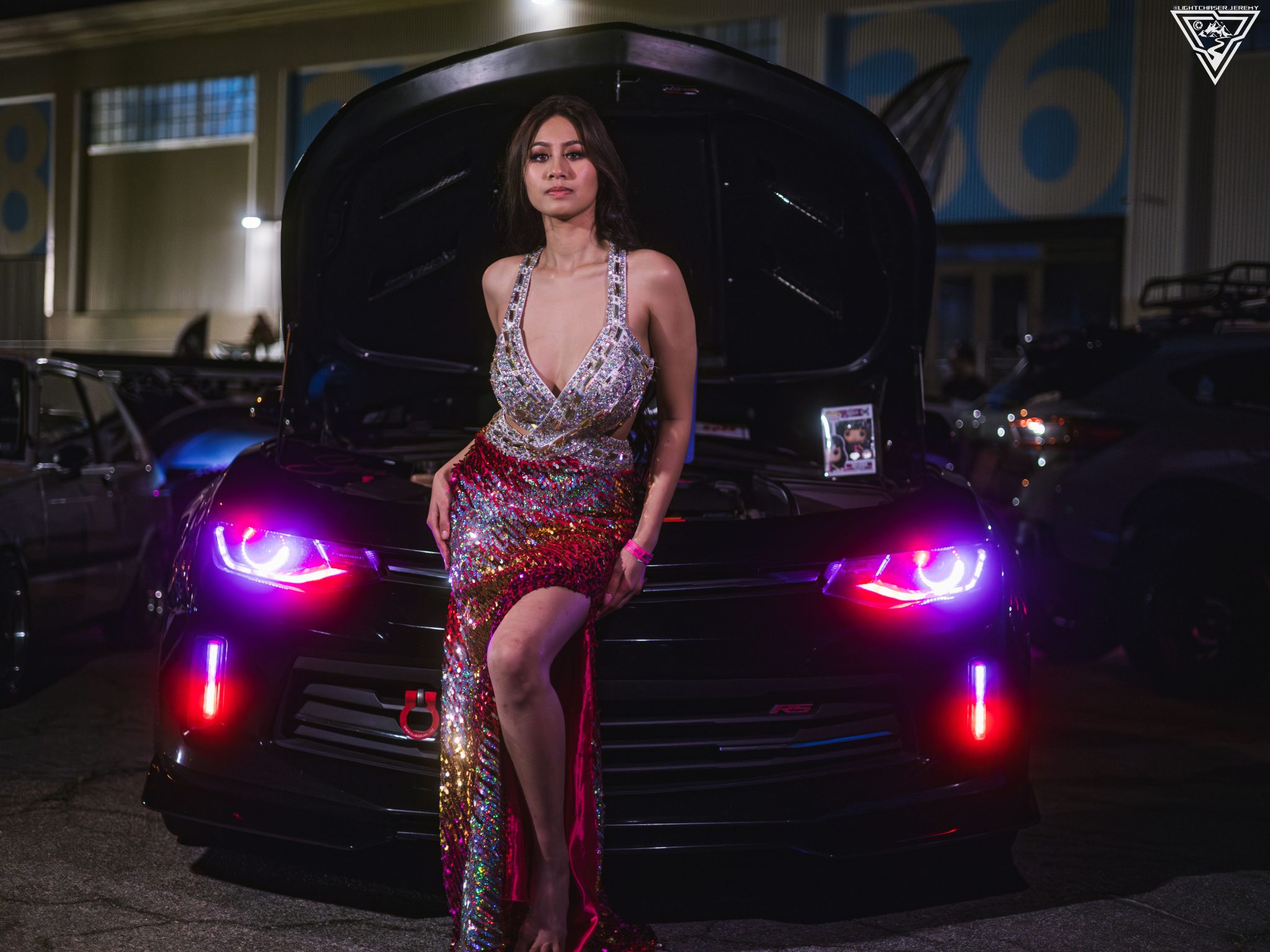Joan Cruz in a sequin gown in front of a show car