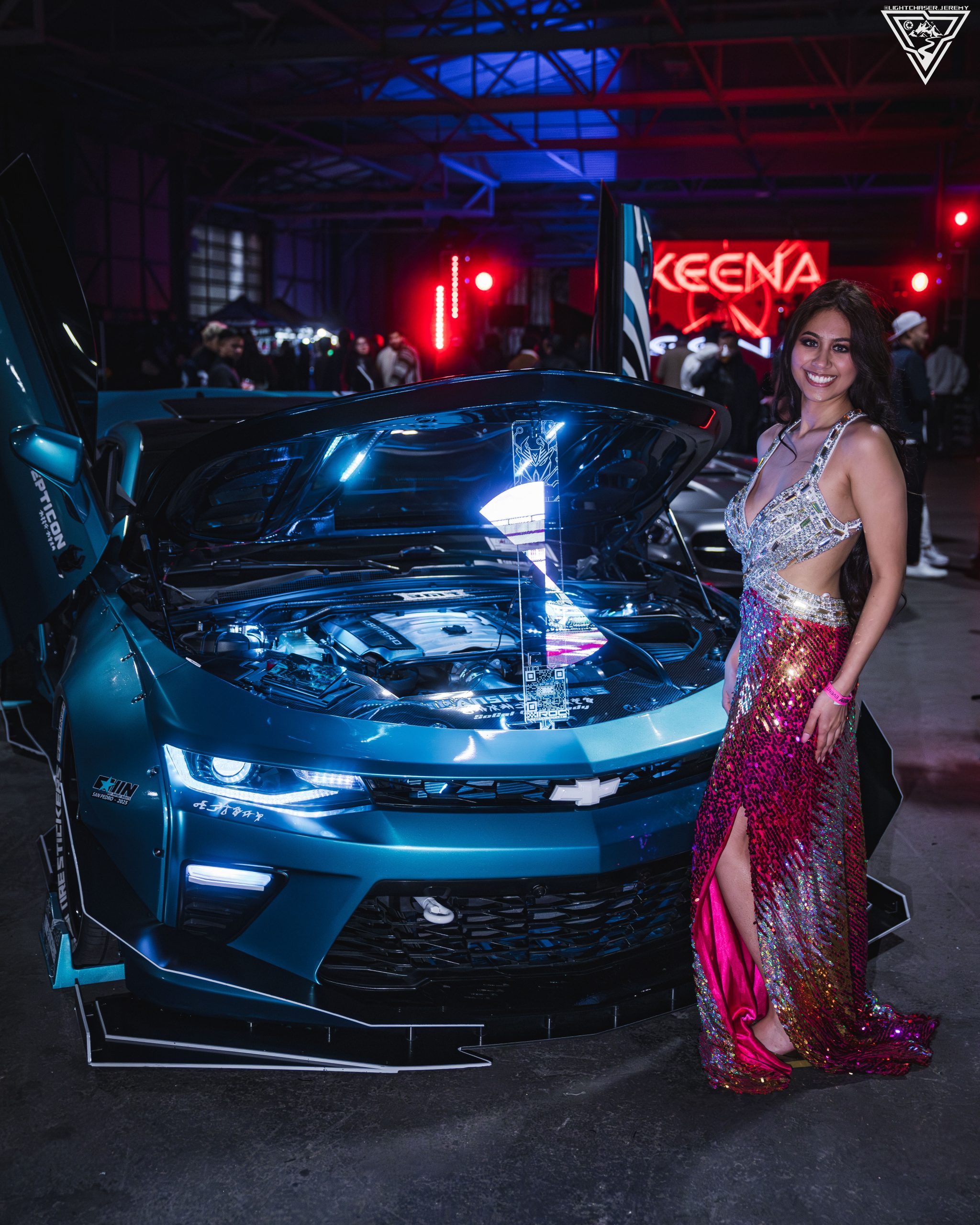 Joan Cruz beside a blue show car with its hood open
