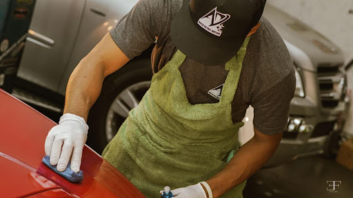 Andrew Ernacio of Auto Detail Nation hand-detailing a red car during a live demo
