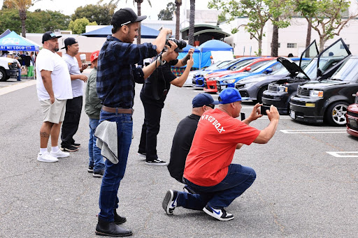 Attendees photographing cars at the car meet photo zone